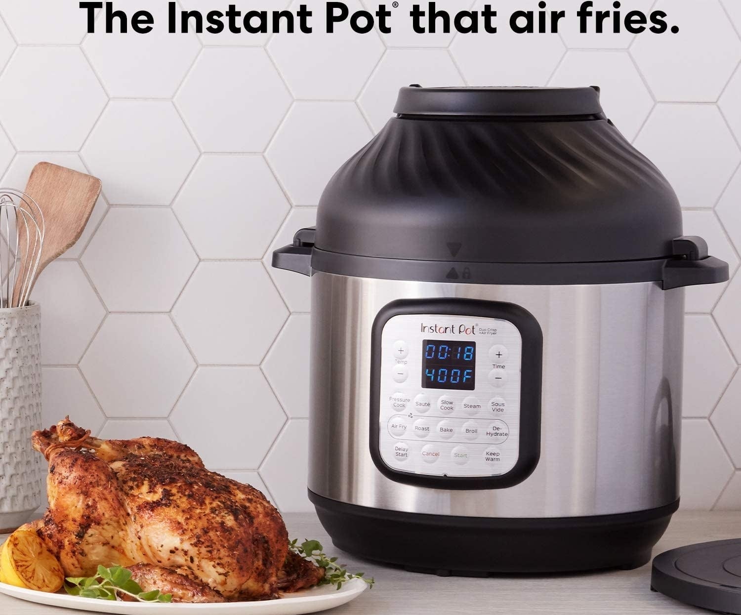 Silver and black instant pot with control panel next to a cooked chicken