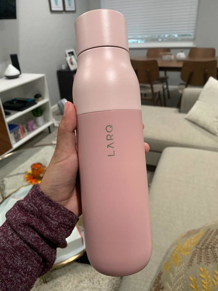 Reviewer is holding a pink water bottle