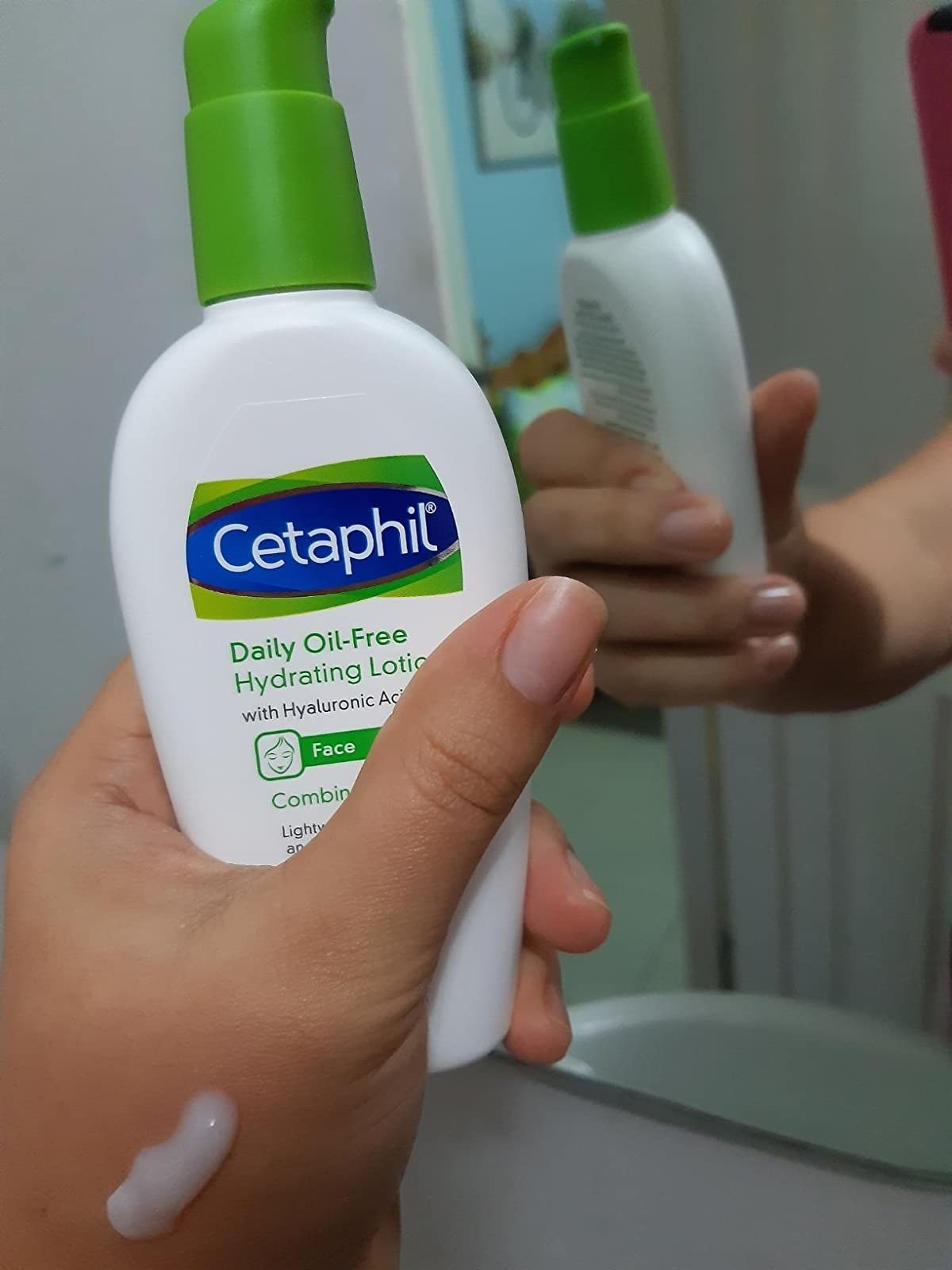 reviewer holding the bottle of lotion