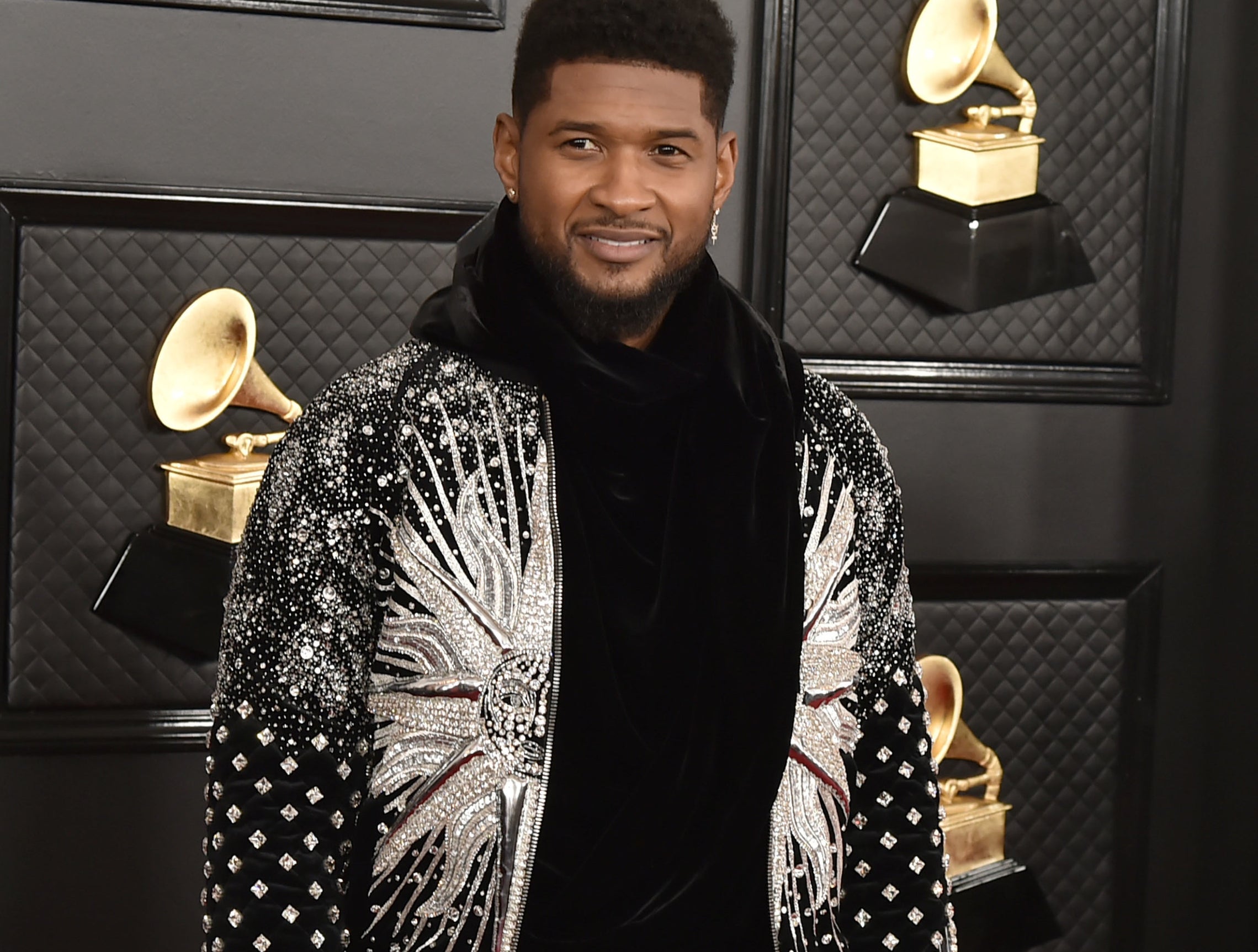 Usher wears a black sweatshirt while on a red carpet