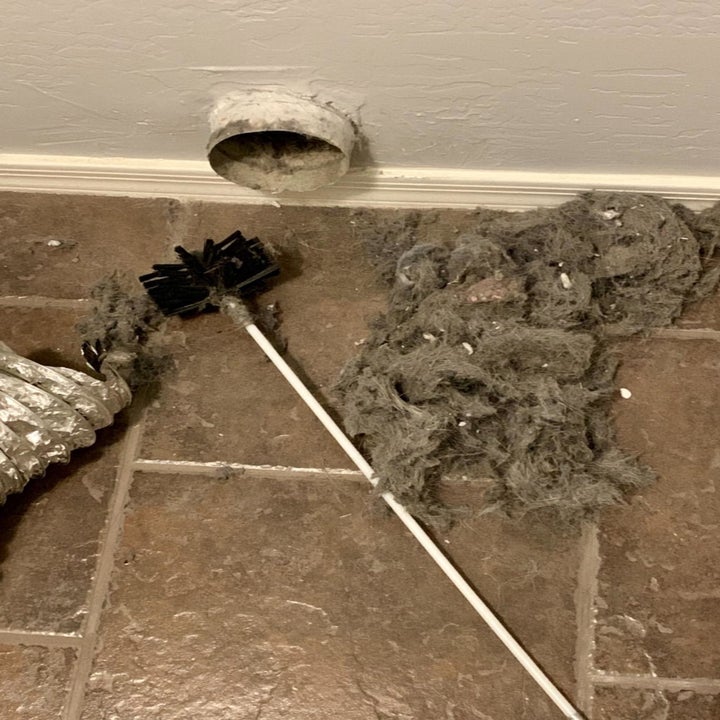 Reviewer's dryer brush next to pile of lint and dust
