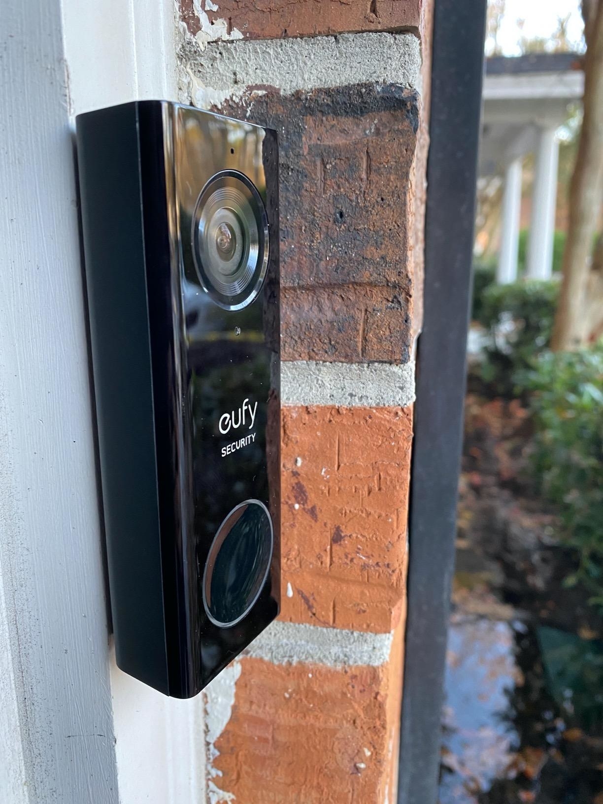 reviewer showing a eufy video doorbell at the front door