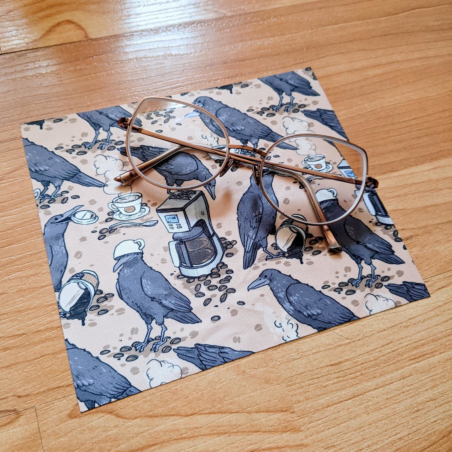 The cleaning cloth with a crow and coffee maker pattern on it