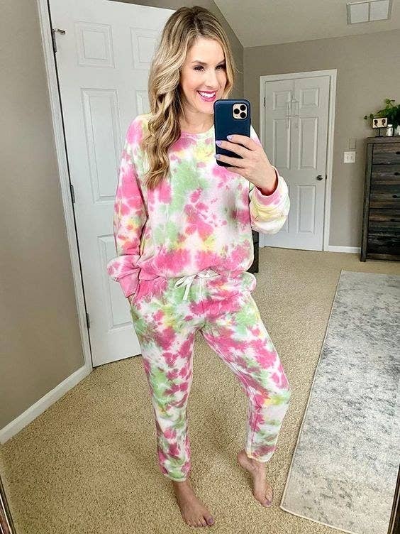 reviewer wearing the full tie dye sweatsuit in green and pink
