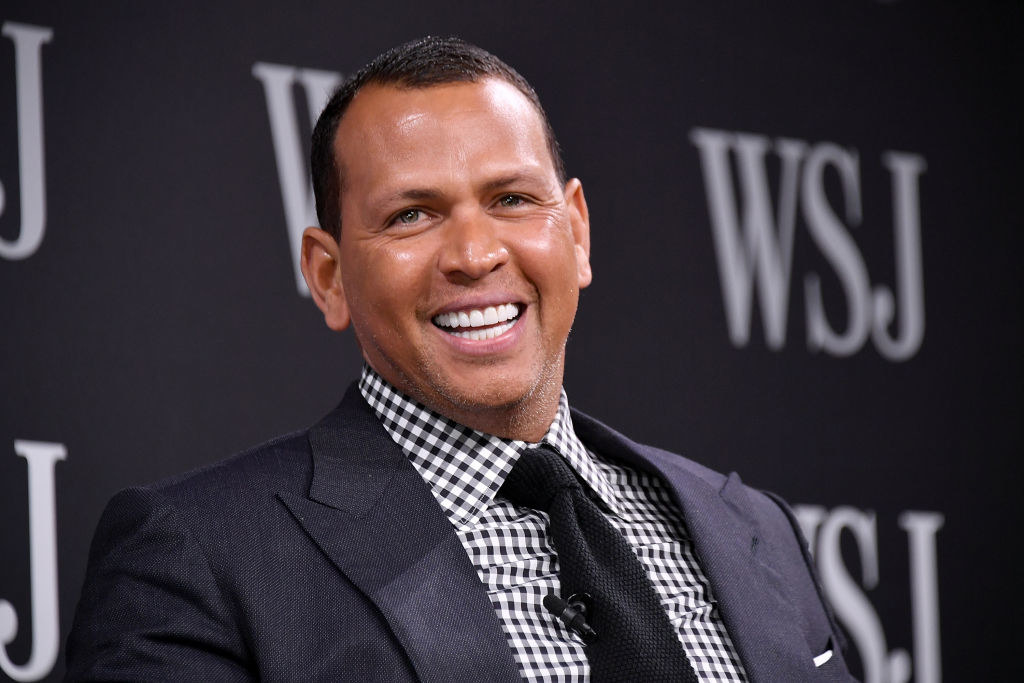 Alex Rodriguez smiles at the camera while attending a Wall Street Journal panel event.