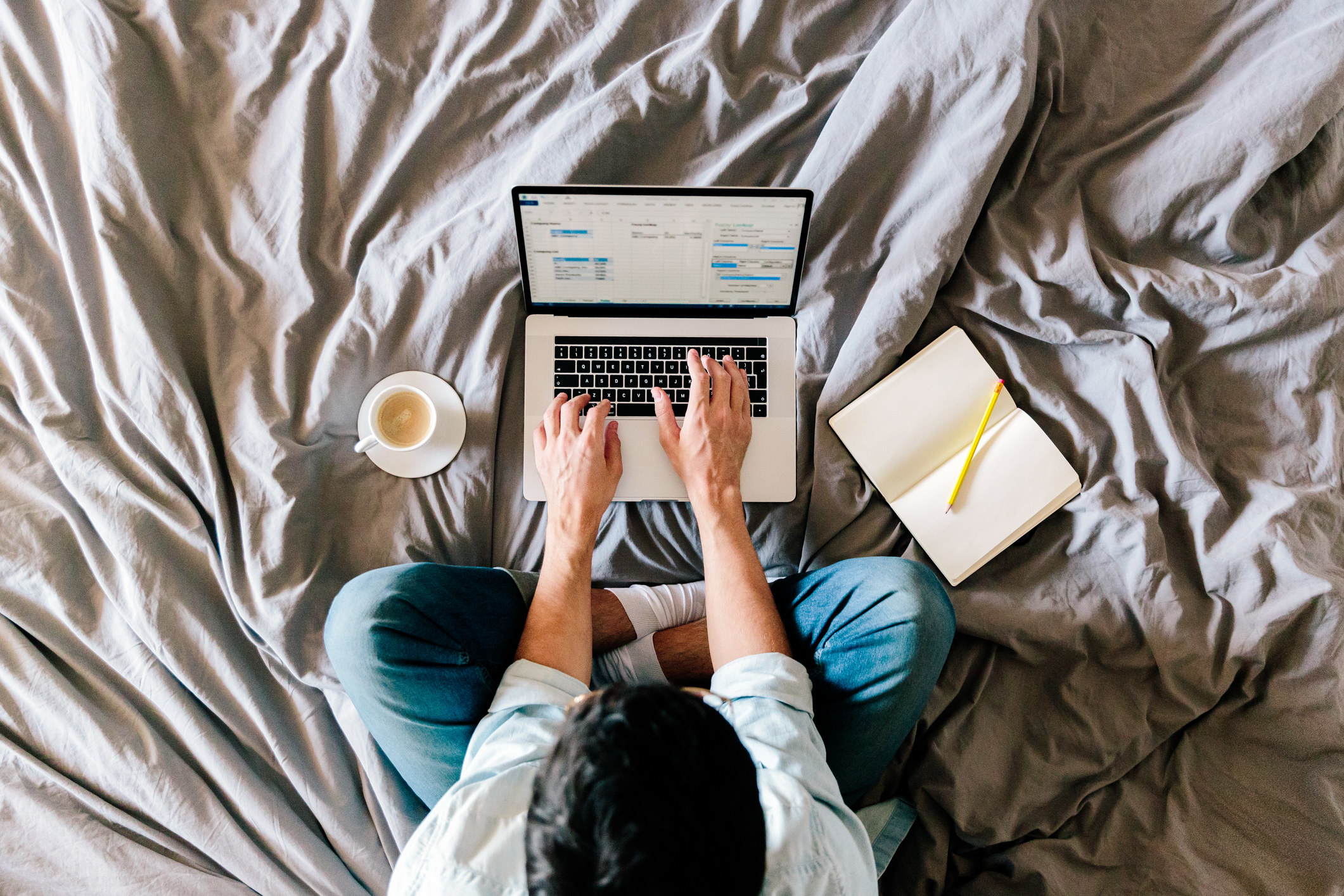 A person working from bed with a laptop