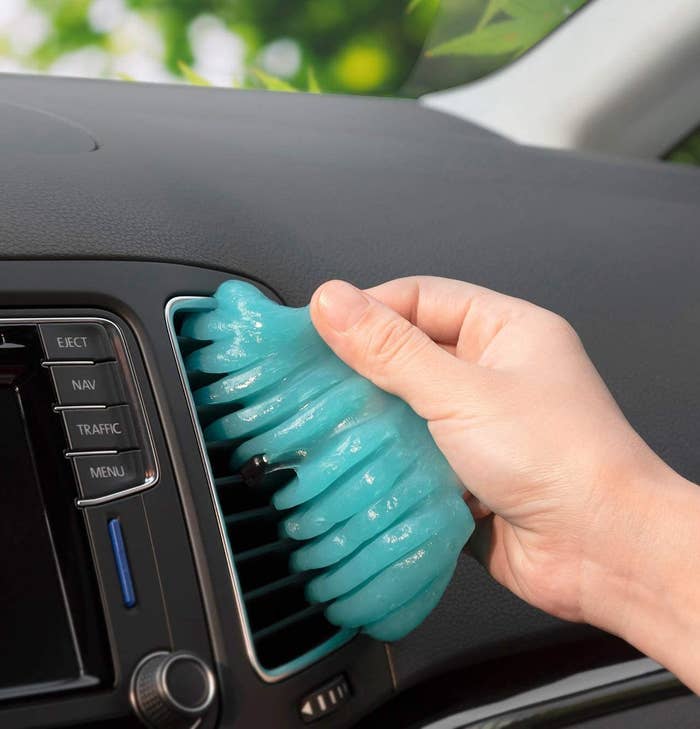 a blue putty being pressed into a car air vent