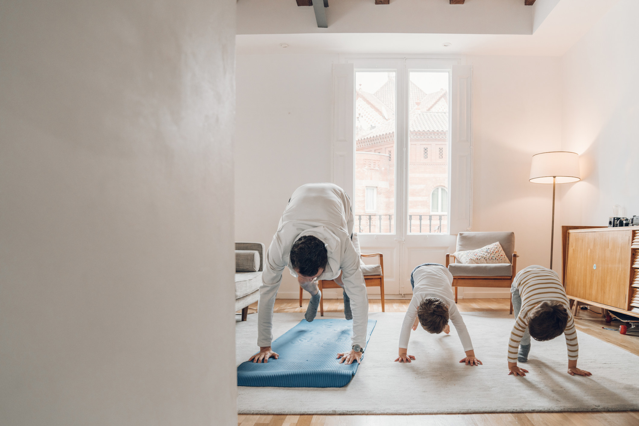 A father and two kids doing yoga.