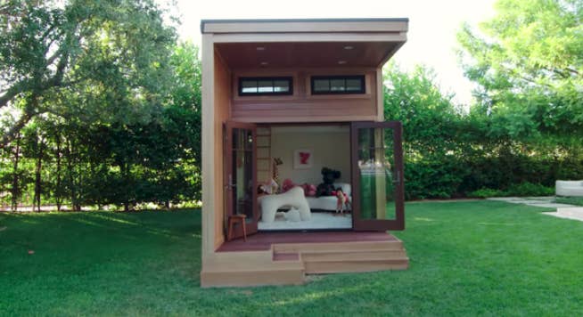 A view of the interior of the &#x27;playhouse&#x27; that shows off the couch filled with stuffed animals