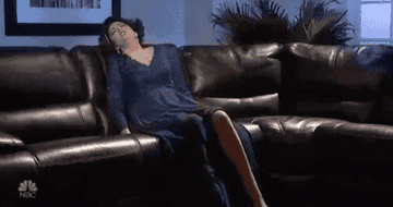 GIF of Cecily Strong from SNL reclining on a couch