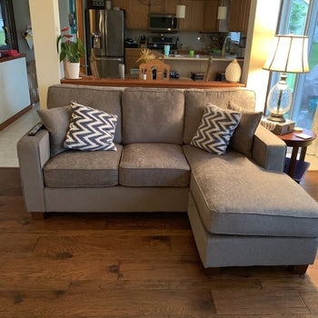 reviewer photo of the couch in gray in the middle of a living room