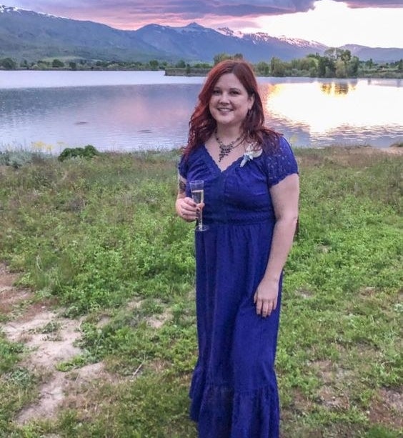 a reviewer wearing the midi length dress in blue