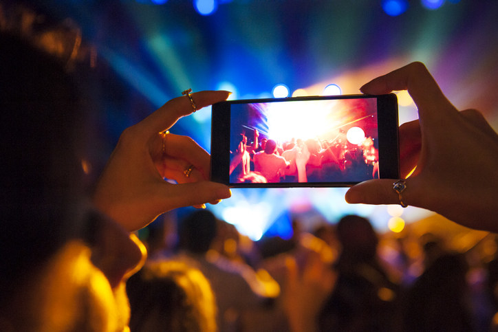 Person holding up their phone at a concert