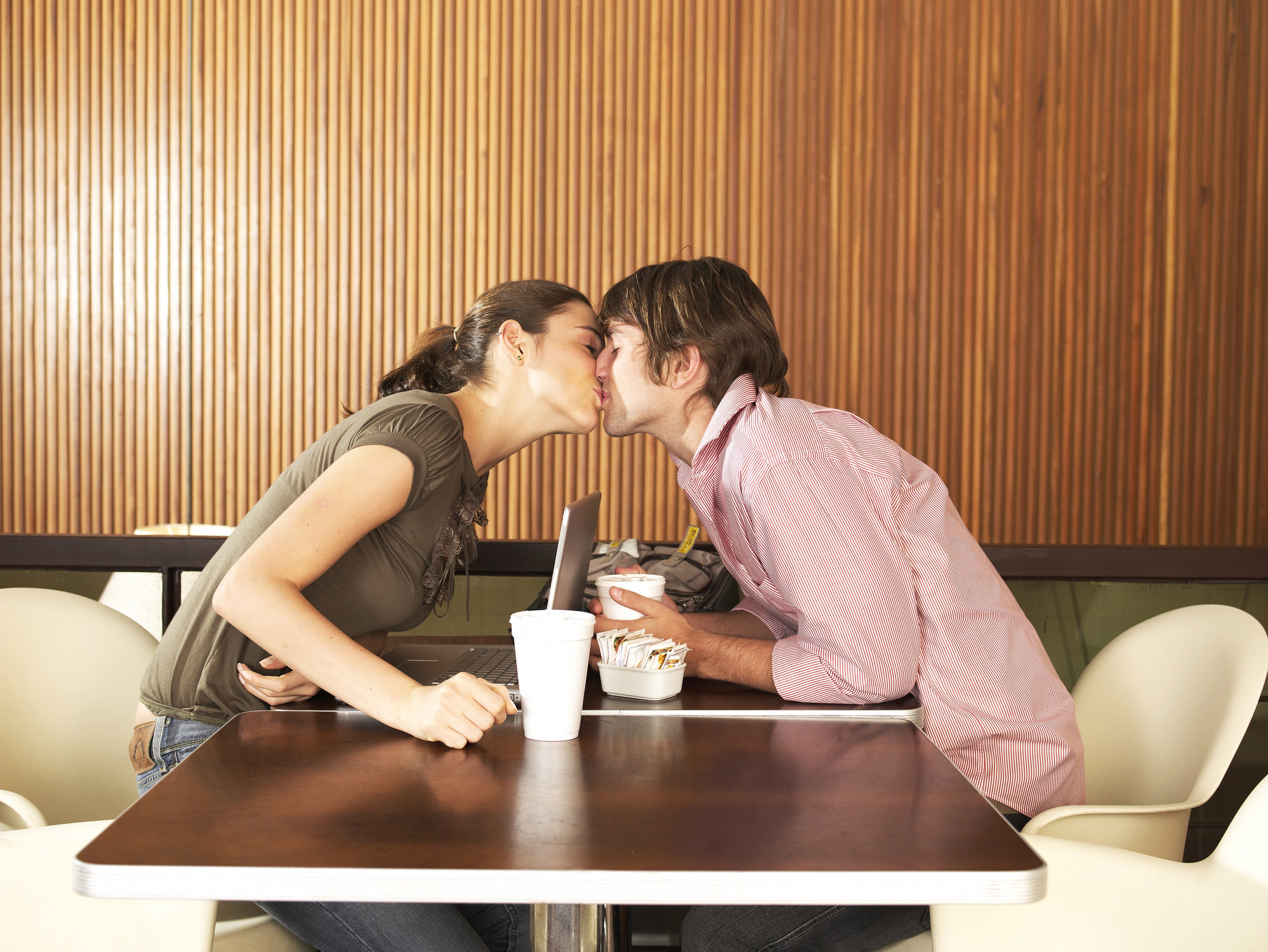 a couple kissing at a restaurant