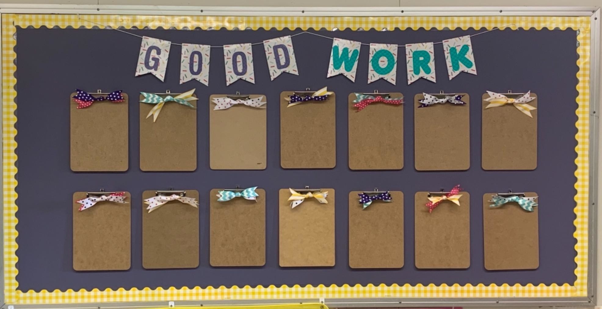 reviewer image of the clipboards mounted on a display wall with the banner, &quot;Good Work&quot;