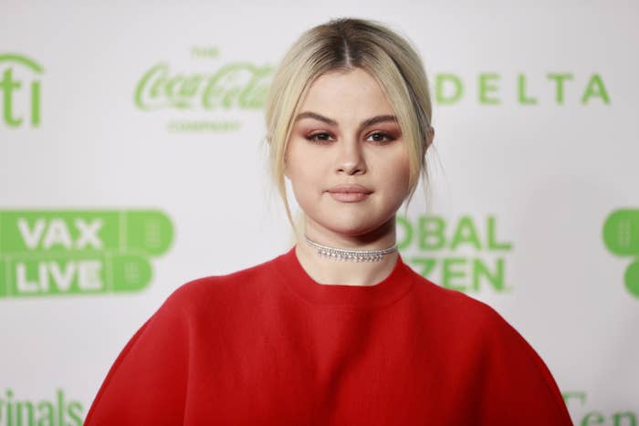 Selena Gomez wears a red top on the red carpet for a concert in 2021