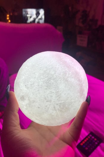 reviewer holding the moon lamp in their hand