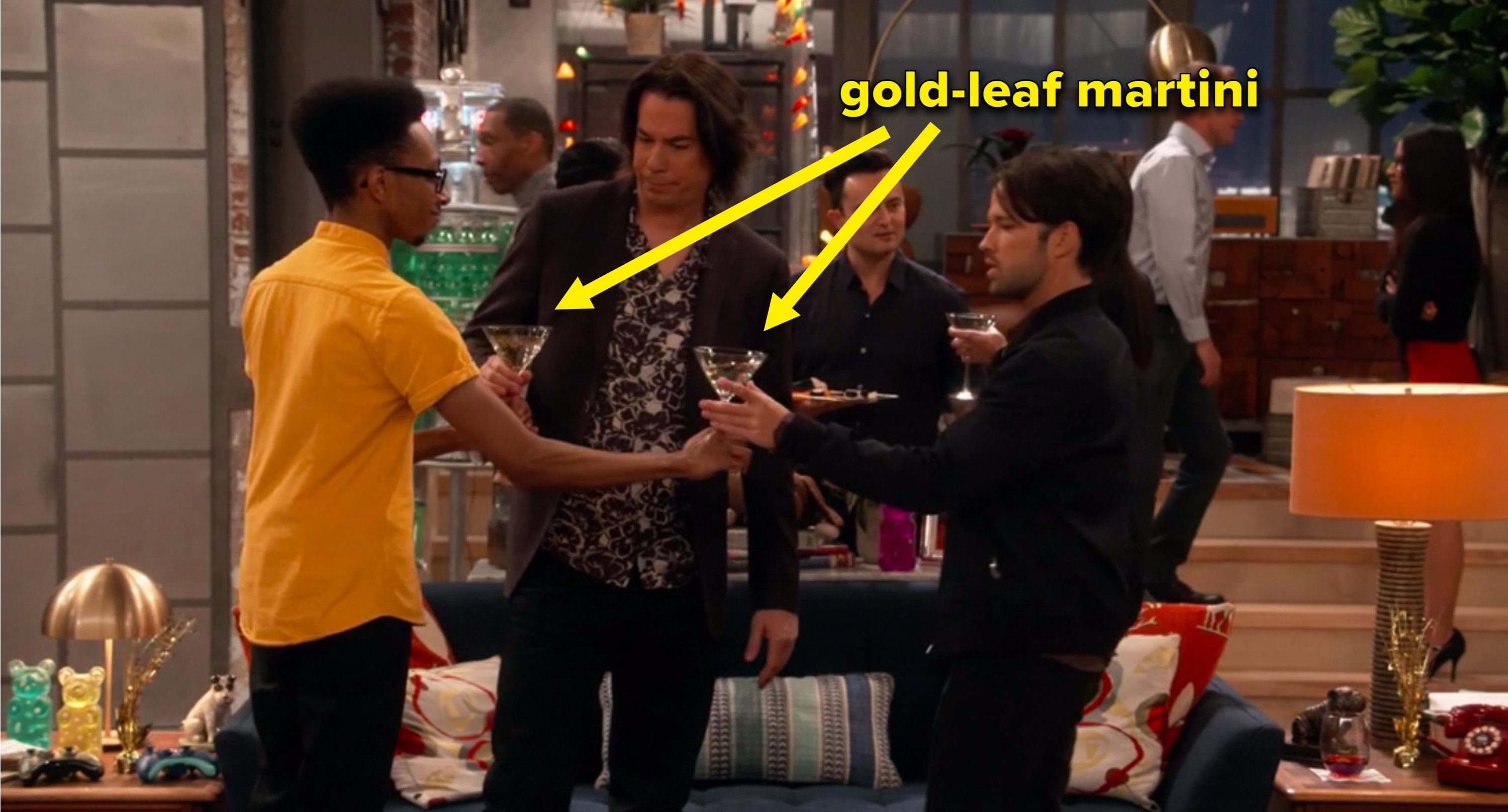 Spencer toasting gold leaf martinis with two people at his house party