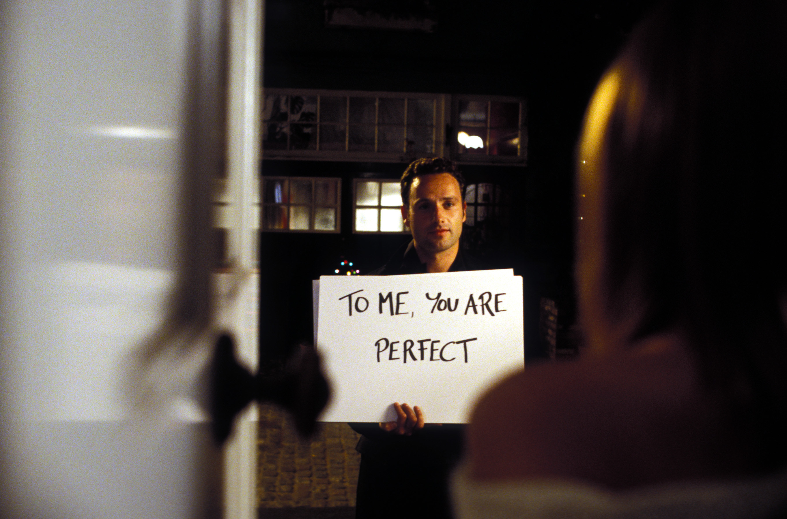 Man holding card that says, &quot;to me you are perfect&quot;