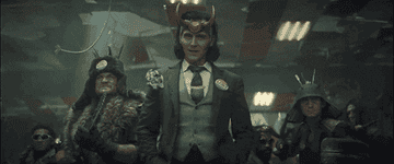 Loki lifts both arms into the air while saying, &quot;Come on.&quot;