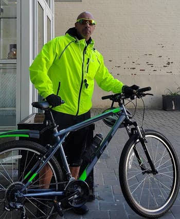 a reviewer wearing the jacket while holding his bike