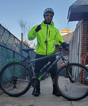 a reviewer wearing the jacket while holding his bike
