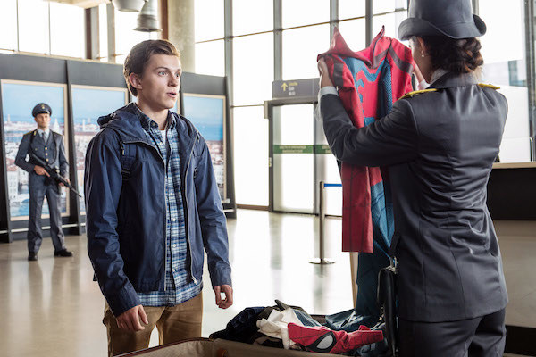 Tom Holland looking surprised that Giada Benedetti is holding the Spider-Man suit