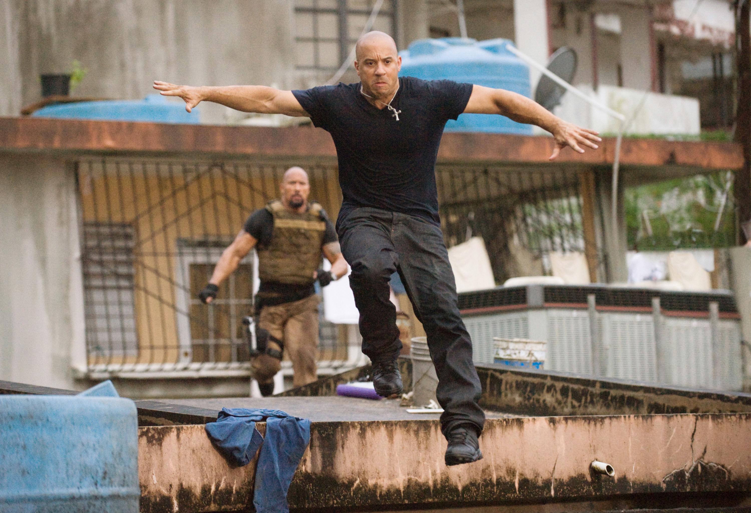 Vin jumps off the edge of a building while Dwayne chases him