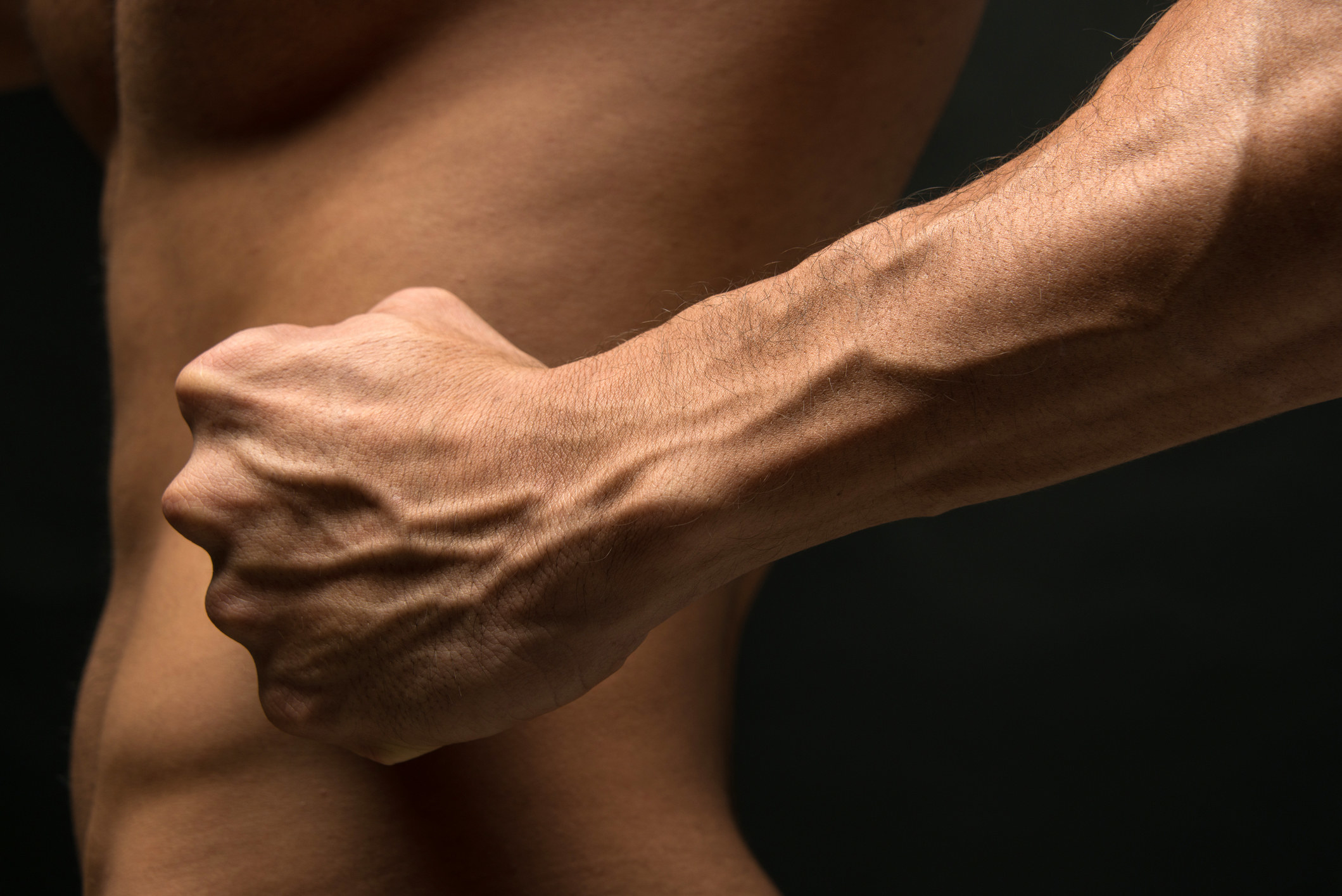 Strong man&#x27;s forearm on black background