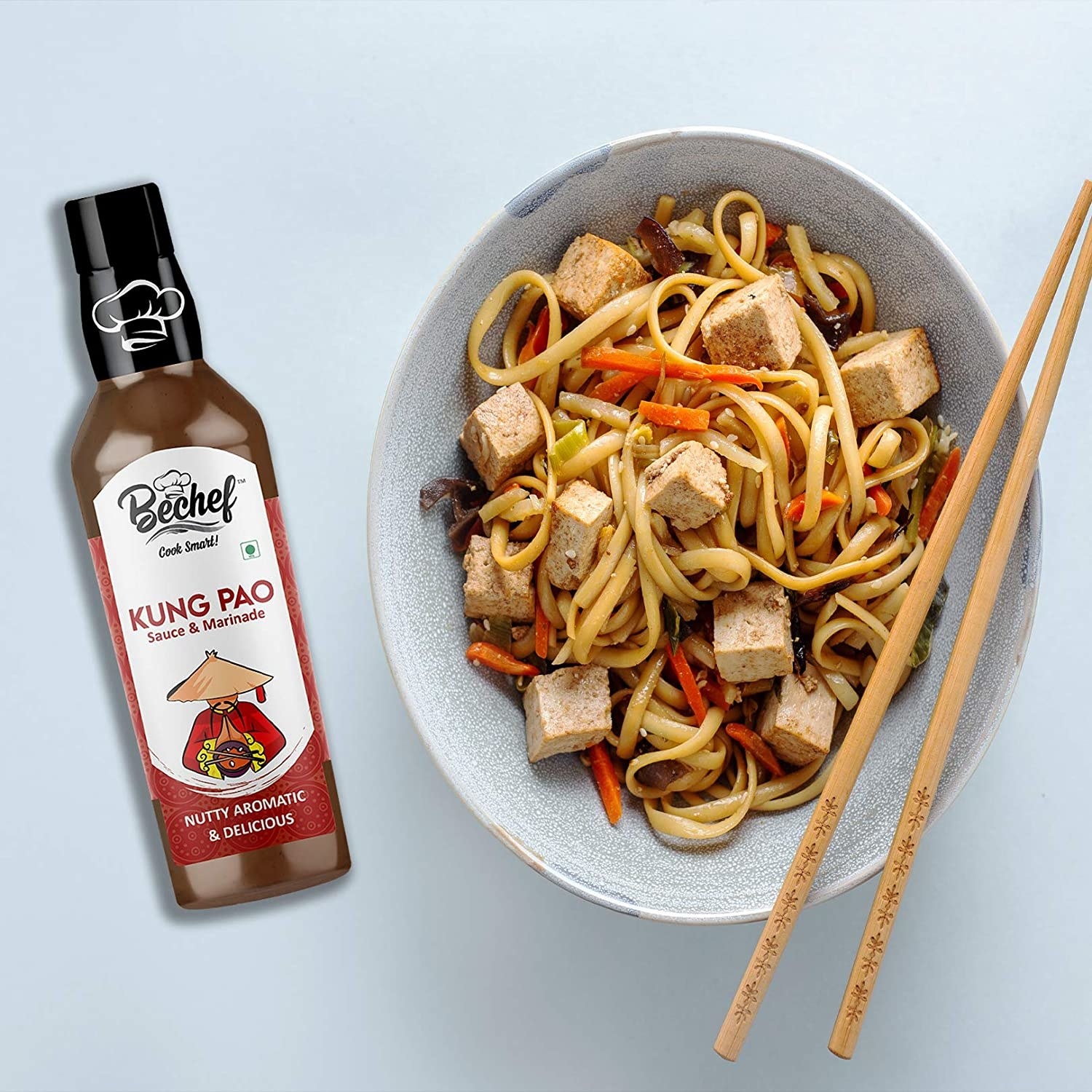 The bottle of kung pao sauce next to a bowl of stir fry.