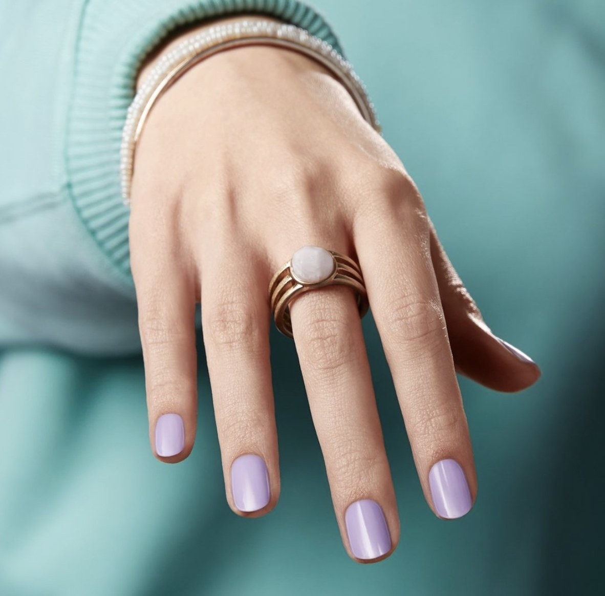A hand with purple nail polish strips
