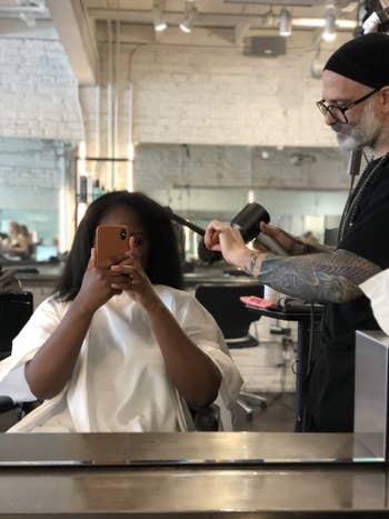 A reviewer's hair being styled with the flat iron