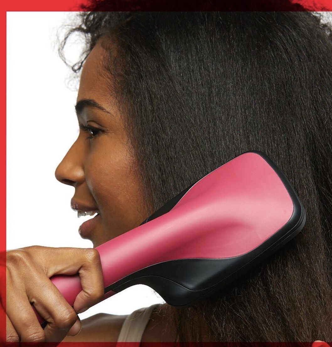 A woman holding a heat-styling tool