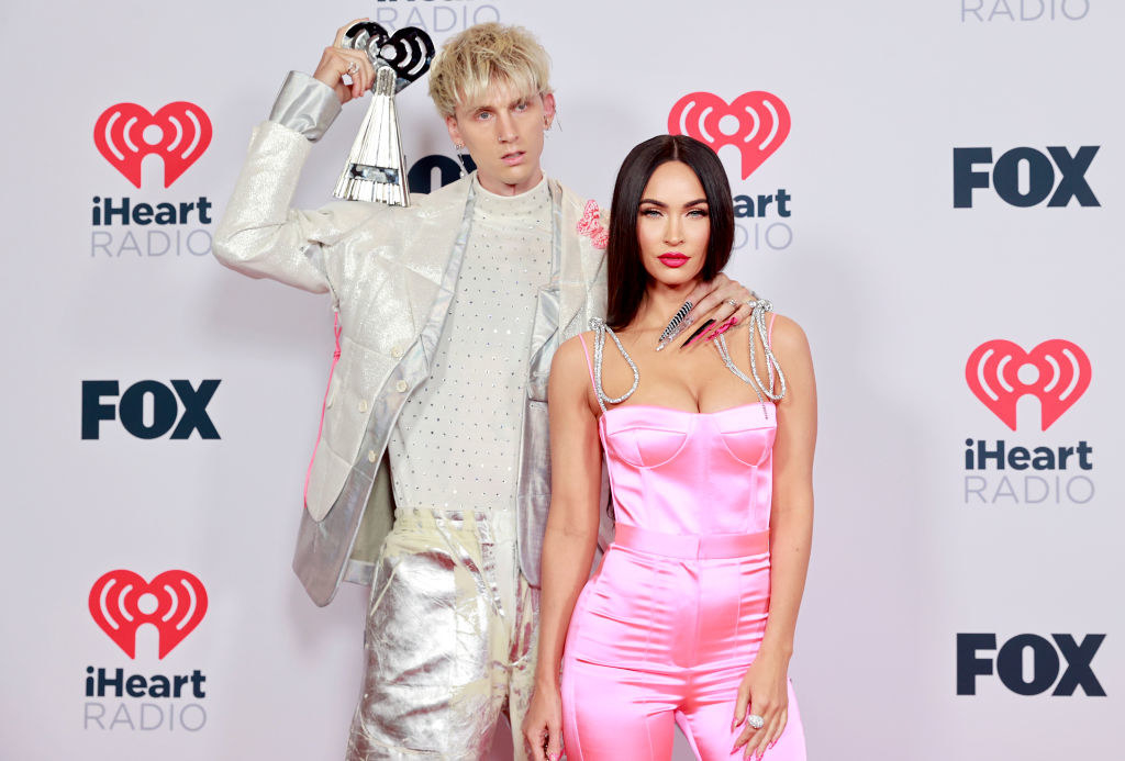 MGK has a pale, smooth jack and pants in the same fabric as Megan&#x27;s satin jumpsuit