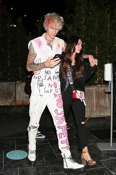 His outfit is covered in graffiti, and hers is classic but edgy