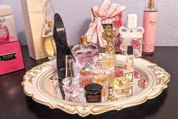 reviewer using the decorative mirror as a tray to hold perfume
