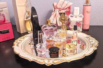 reviewer using the decorative mirror as a tray to hold perfume
