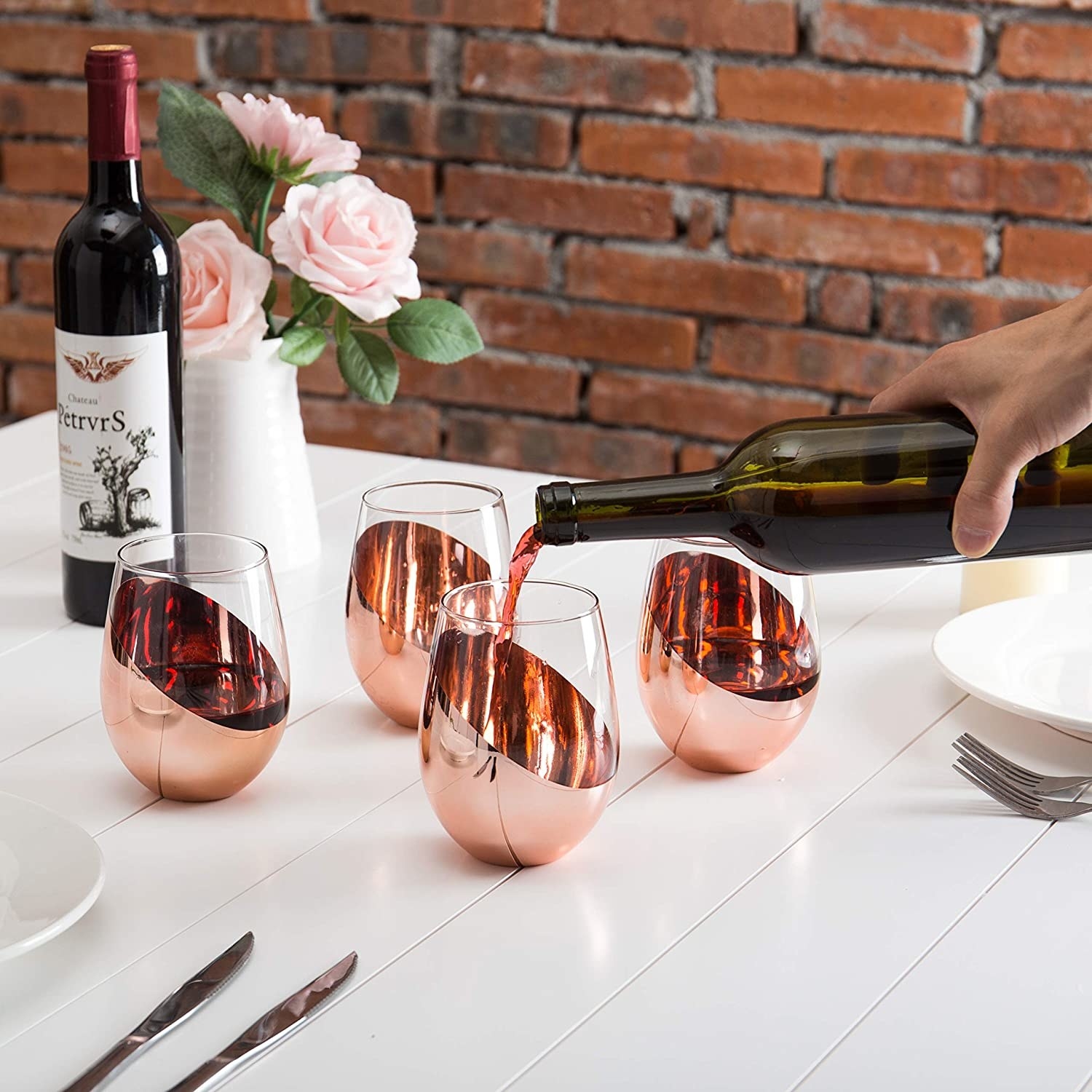 model pouring red wine into a wine glass with a copper design