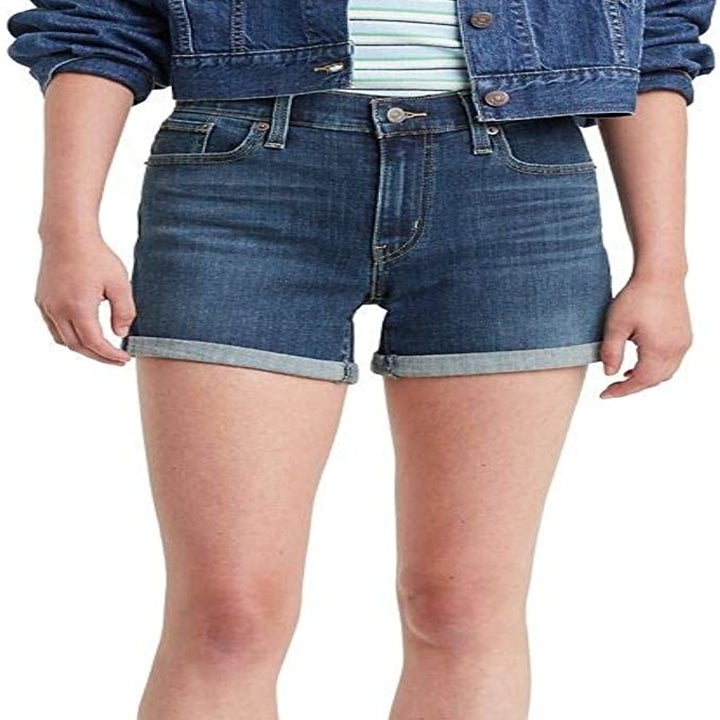 a person wearing denim shorts from the front