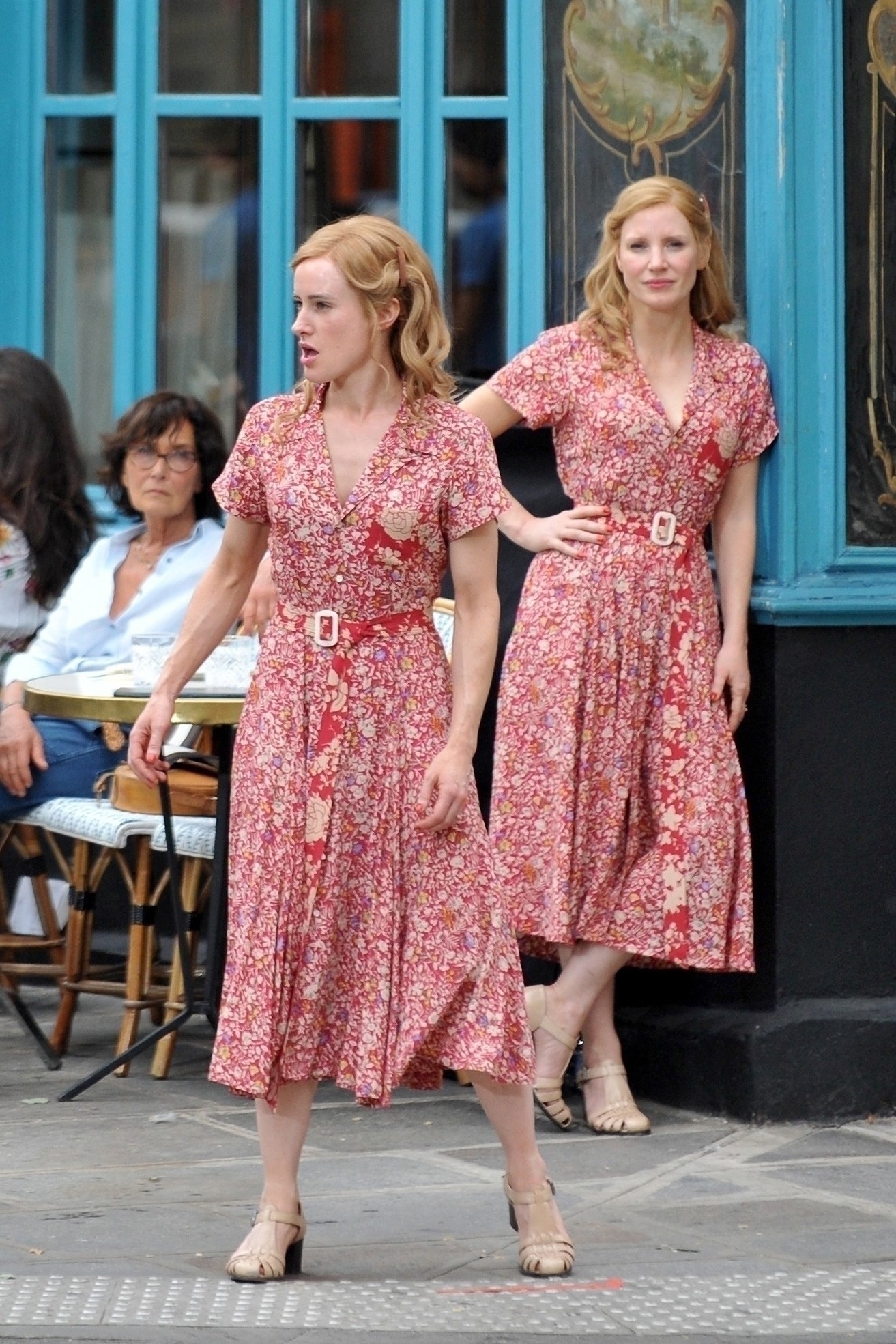 Jessica Chastain and her stunt double sporting matching floral dresses and nude heels