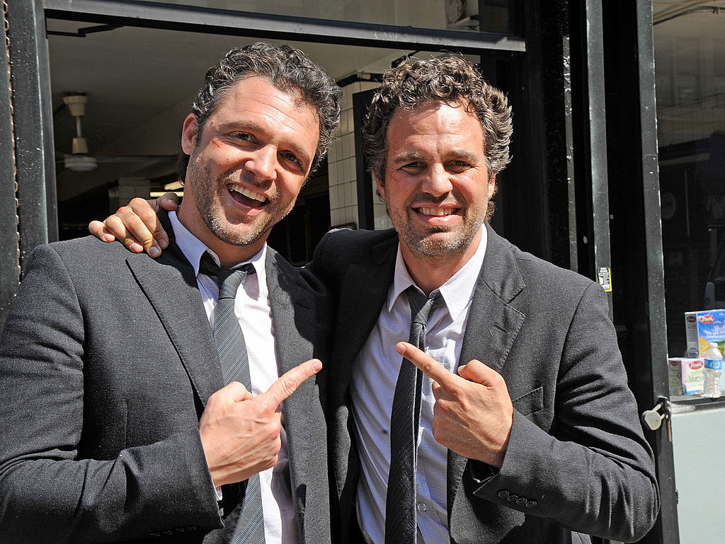 Mark Ruffalo pointing to his stunt double who is pointing at him, they&#x27;re both wearing the same suit and their hair is styled in the same fashion