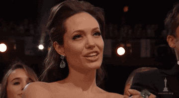 Angelina Jolie claps and smiles at The Academy Awards