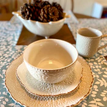 Close-up of a bowl on top of two plates and a matching mug 