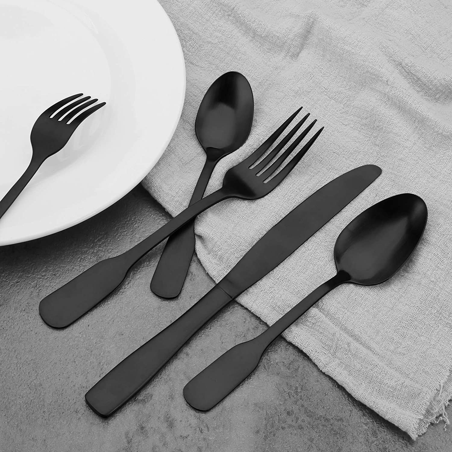 several utensils in matte black on top of a linen napkin