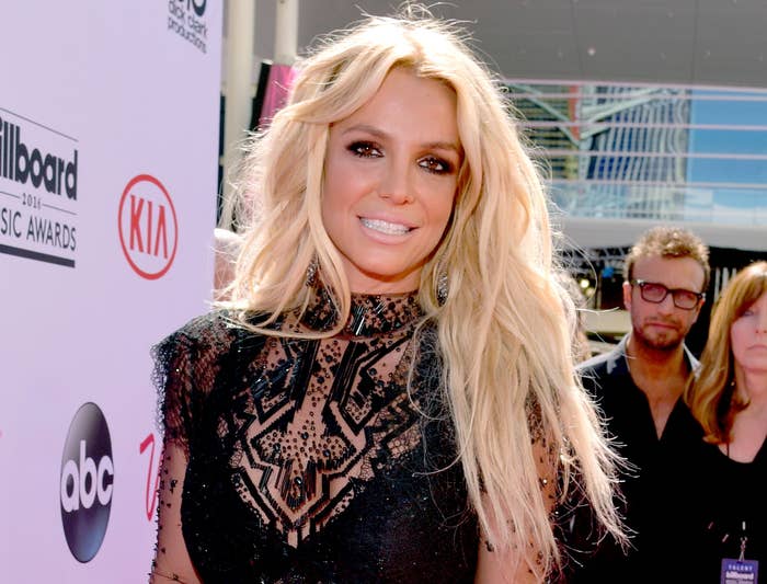 Britney smiles in a black dress with sheer long sleeves
