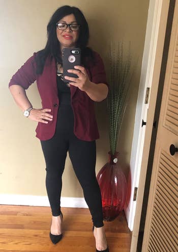 a reviewer mirror selfie of someone wearing the leggings with heels and a blazer 