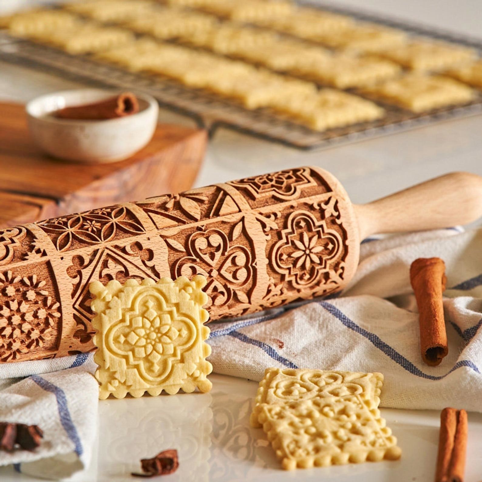 the vintage embossing rolling pin next to cuts of dough with floral embossed designs