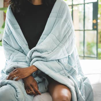 a model wearing the blanket around their shoulders 