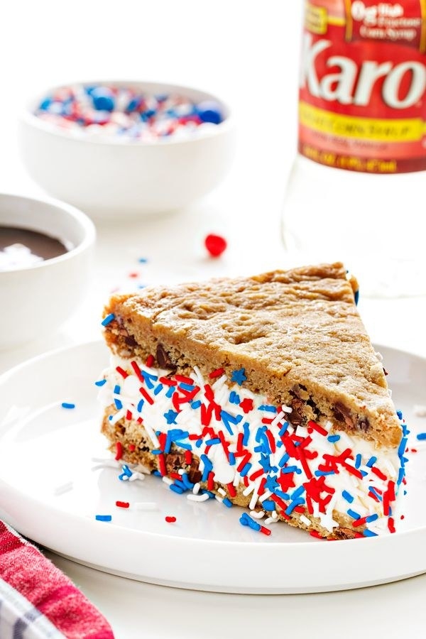 A cookie ice cream sandwich with red, white, and blue sprinkles.