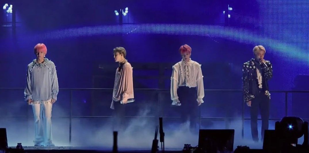 The vocal line of BTS stand in a line onstage to perform The Truth Untold